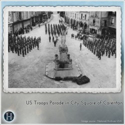 Statue of an angelic figure holding a torch, standing on a decorated pedestal (Carentan, Normandy 1944, France) (1)