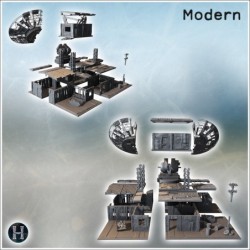 Satellite dish with adjacent structures, barrels, and fortified surroundings in rugged terrain (4)